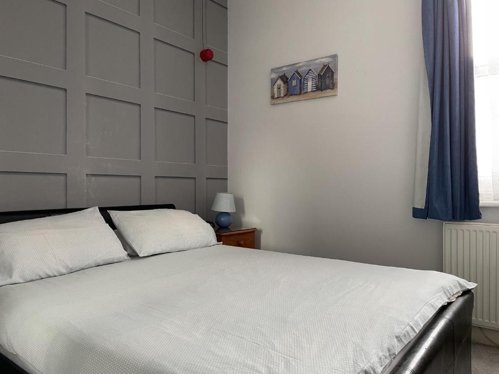 a bedroom with a white bed and a window at Burton Villa Guest House in York