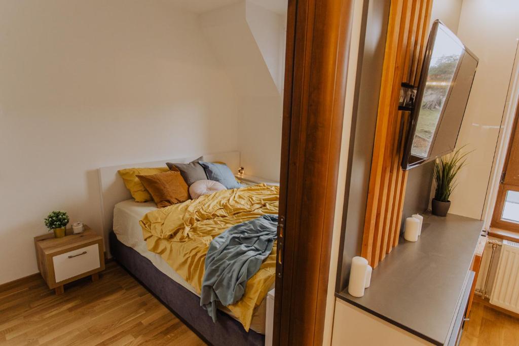 una piccola camera da letto con un letto con lenzuola gialle di Divcinova Moderan A10 a Divčibare
