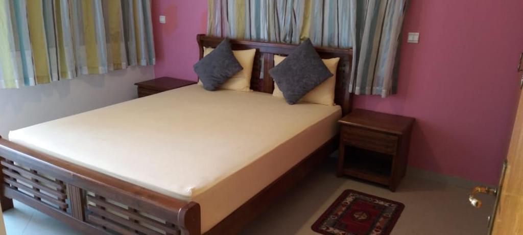 ein Schlafzimmer mit einem Bett in einem rosa Zimmer in der Unterkunft Villa Saraya in Mehdiya-Plage