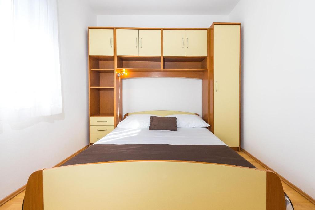 - une petite chambre avec un lit et des étagères dans l'établissement Apartment Vrsi - Mulo 5951d, à Vrsi