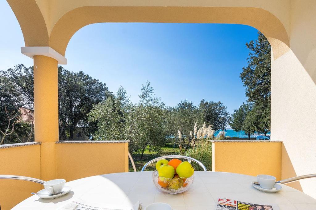 - une table avec un bol de fruits sur le balcon dans l'établissement Apartments by the sea Vrsi - Mulo, Zadar - 5951, à Vrsi