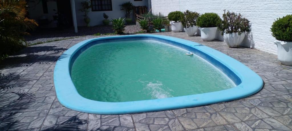 una piscina azul de agua en un patio en Pousada do Nico, en São Gabriel