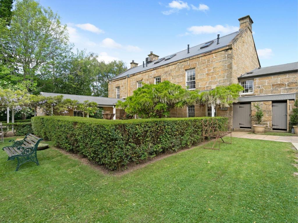 a brick house with a hedge in the yard at The Red Feather Inn in Launceston