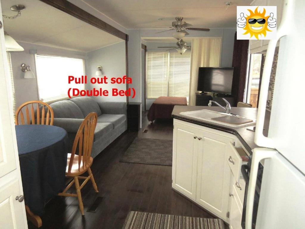 a kitchen and a living room with a couch and a table at Boardwalk RV Rental Site #19 in Cavendish