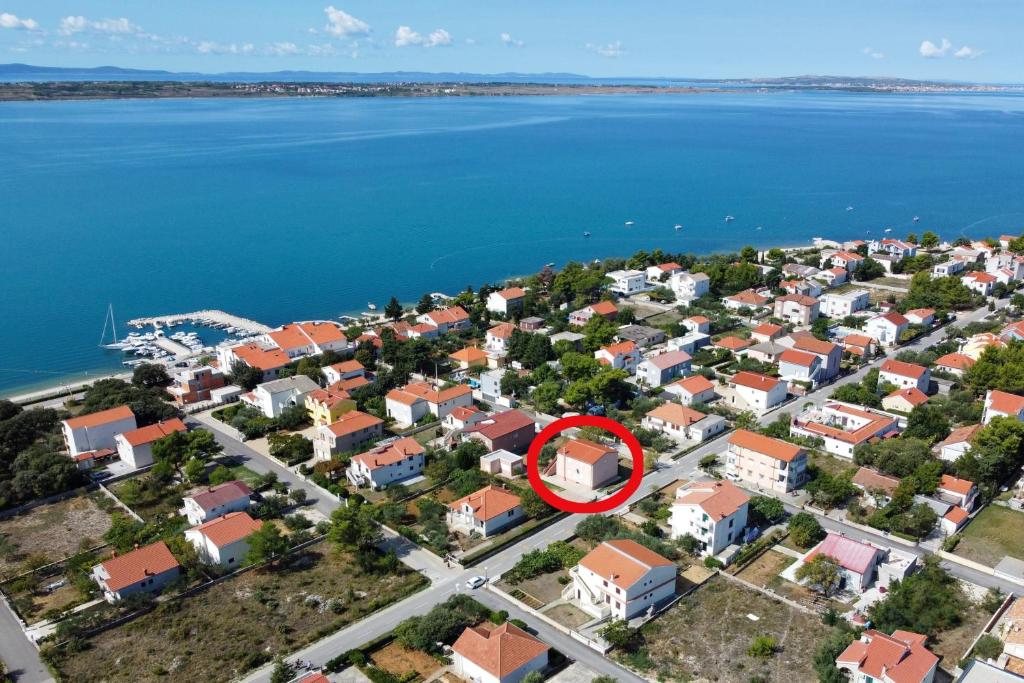 Apartments by the sea Vrsi - Mulo, Zadar - 18914 في فرسي: اطلالة جوية على مدينة عليها دائرة حمراء