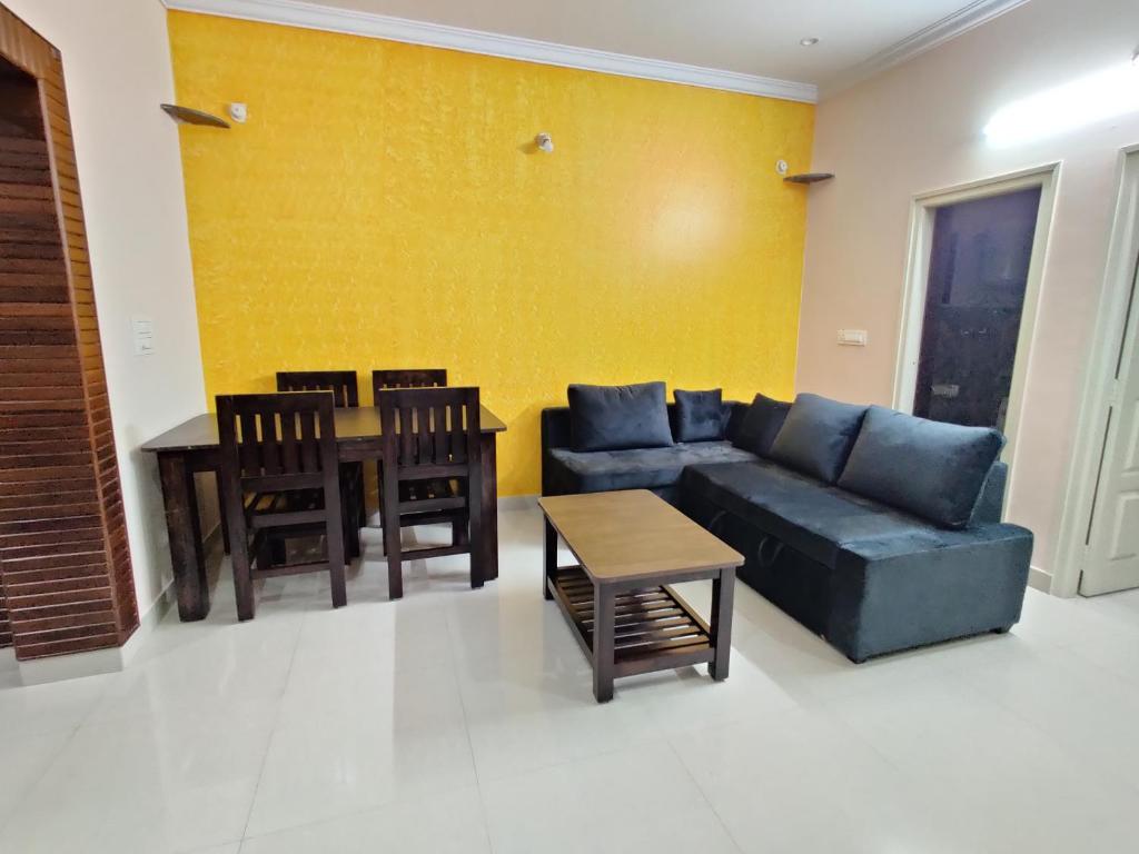 sala de estar con sofá y mesa en SV Serviced Apartments, en Chikmagalur