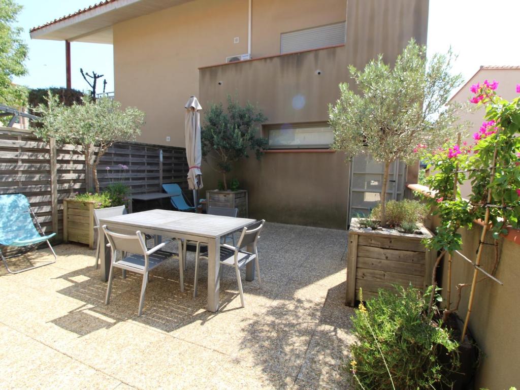um pátio com uma mesa, cadeiras e plantas em Appartement Collioure, 2 pièces, 4 personnes - FR-1-309-233 em Collioure