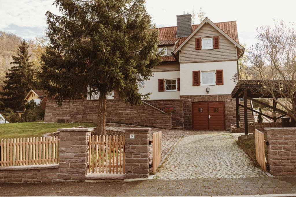 een wit huis met een houten hek en een hek bij Waldchalet Am Steinberg FEWO in Wernigerode