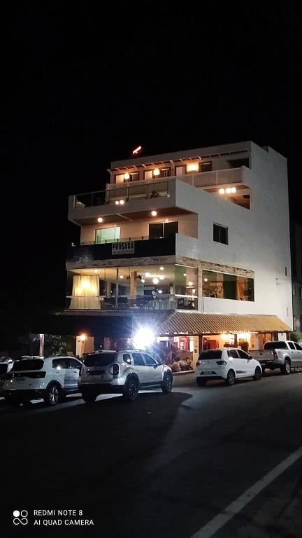 een gebouw waar 's nachts auto's voor geparkeerd staan bij Pousada Mariza in Guarabira