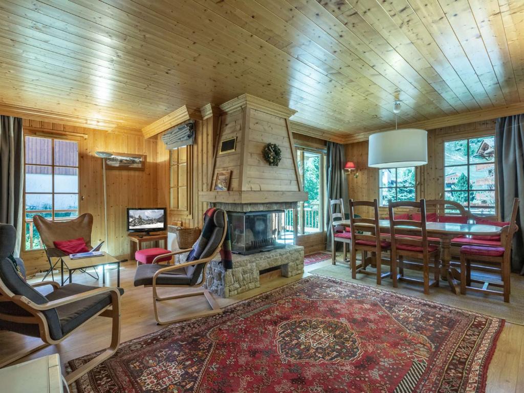 - un salon avec une cheminée et une table à manger dans l'établissement Appartement standing 3 pièces avec terrasse, cheminée, parking et WiFi à Val-d'Isère - FR-1-694-199, à Val dʼIsère