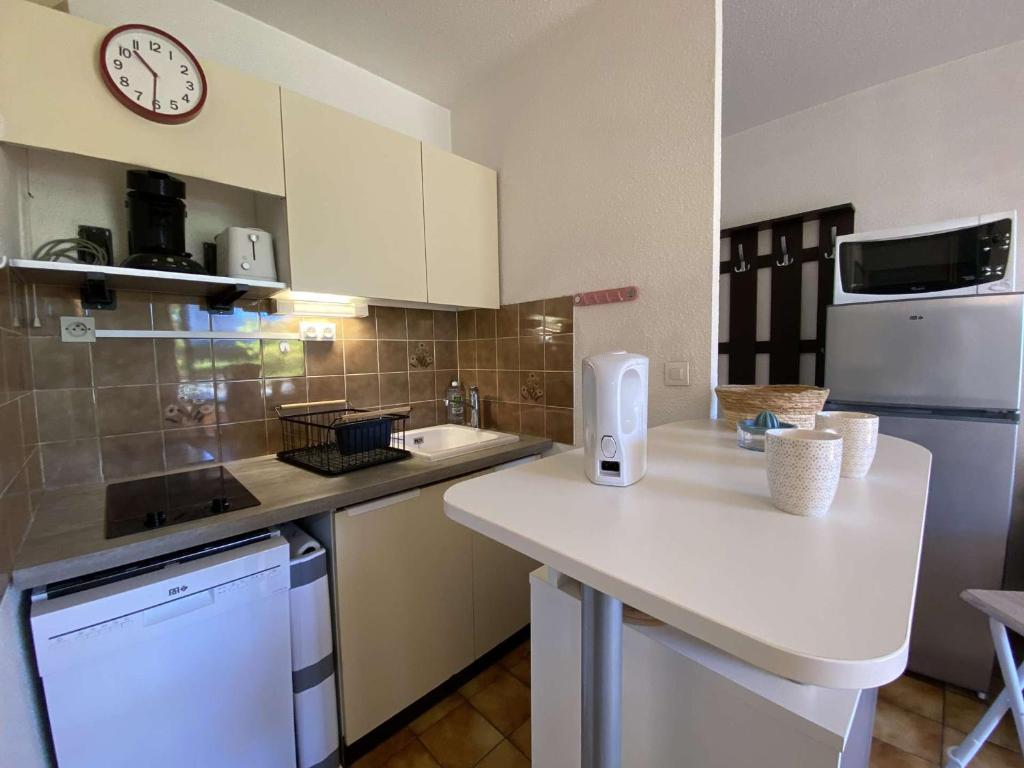 a kitchen with a counter and a clock on the wall at Appartement Sainte-Maxime, 2 pièces, 4 personnes - FR-1-226-500 in Sainte-Maxime