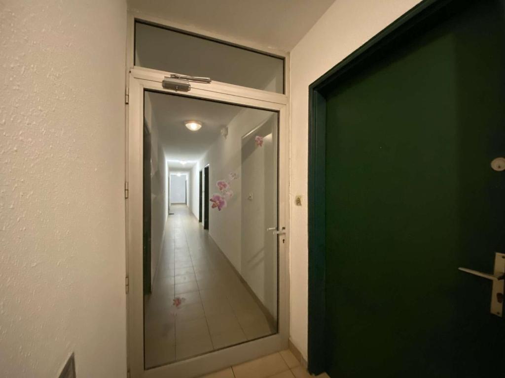 an empty hallway with a green door and a corridor at Appartement Sainte-Maxime, 2 pièces, 4 personnes - FR-1-226-500 in Sainte-Maxime