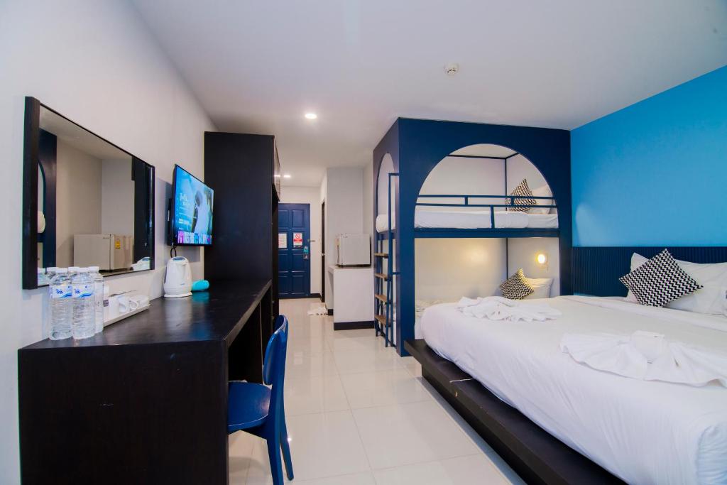 a bedroom with a large bed and a blue wall at Sleep Whale Hotel in Krabi town