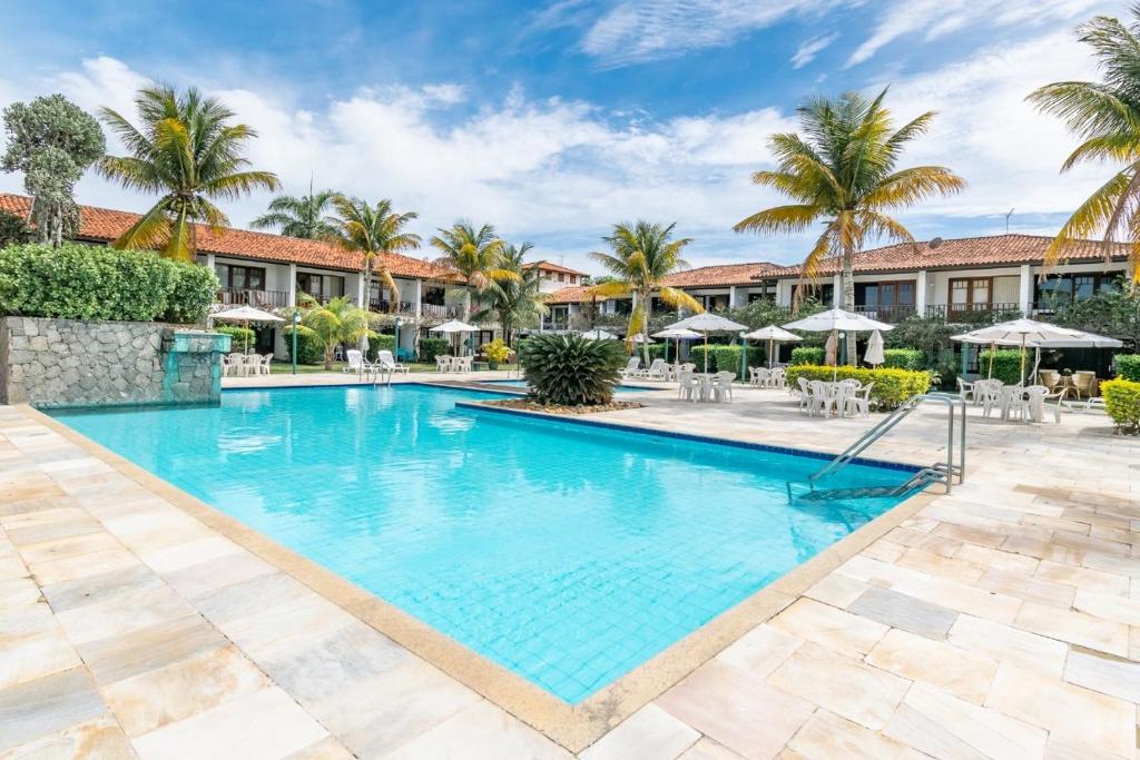 uma piscina num resort com palmeiras em Búzios casa 41 em Búzios