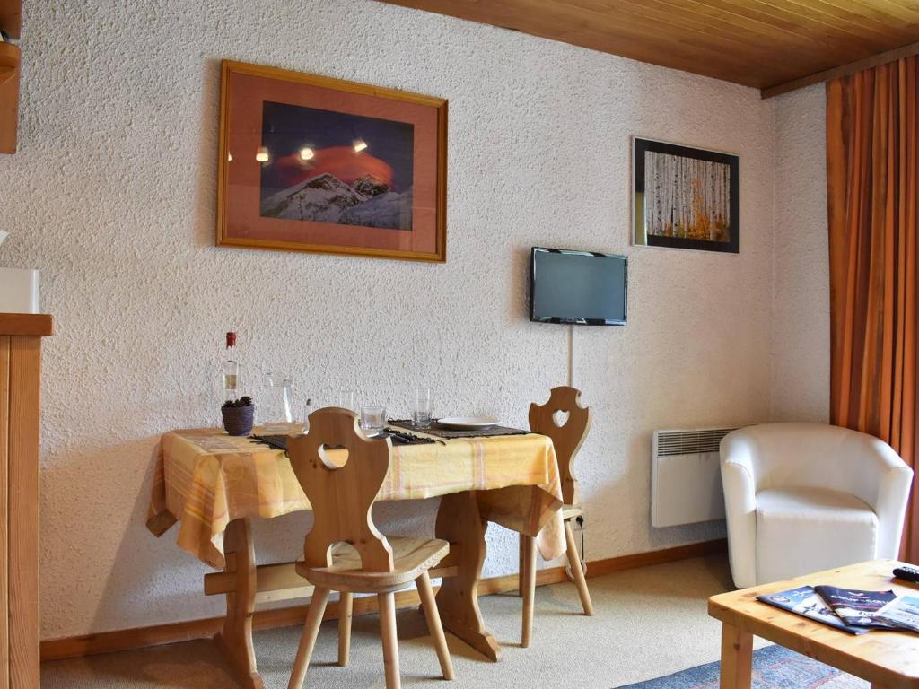 a room with a table and chairs and a television at Appartement Méribel, 1 pièce, 4 personnes - FR-1-180-10 in Méribel