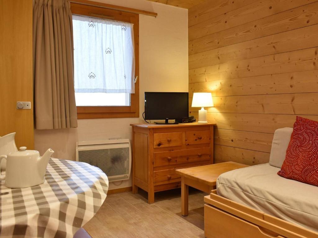 - une chambre avec un lit et une télévision sur un mur en bois dans l'établissement Studio de Montagne pour 2 pers, Pistes et Commerces à 100m, Méribel - FR-1-180-5, à Méribel