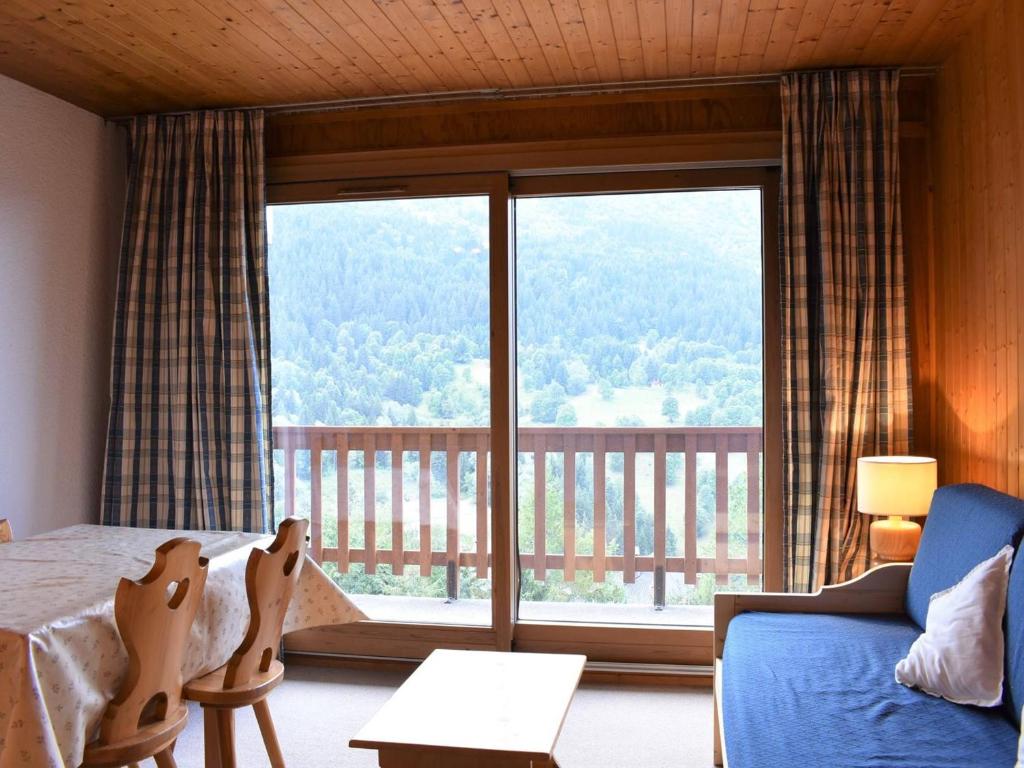 a bedroom with a bed and a large window at Appartement Méribel, 1 pièce, 3 personnes - FR-1-180-19 in Méribel