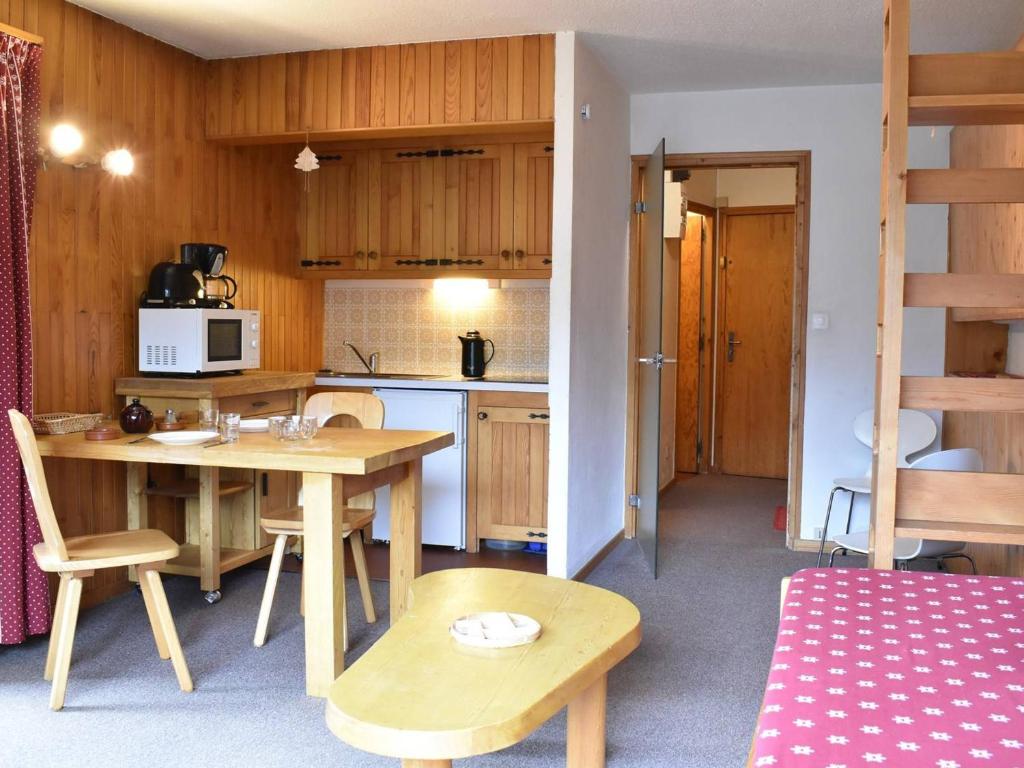 een keuken met een tafel en stoelen en een keuken met een ladder bij Appartement Méribel, 1 pièce, 3 personnes - FR-1-180-21 in Méribel