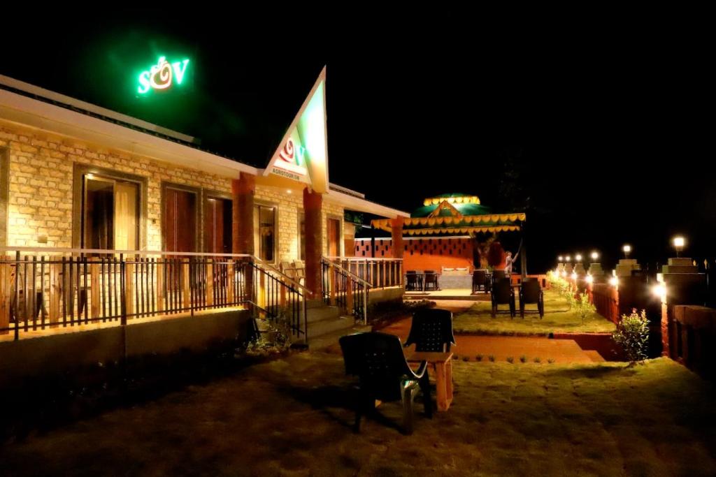 a building with a green sign on it at night at Sara green Valley Farm in Mahabaleshwar