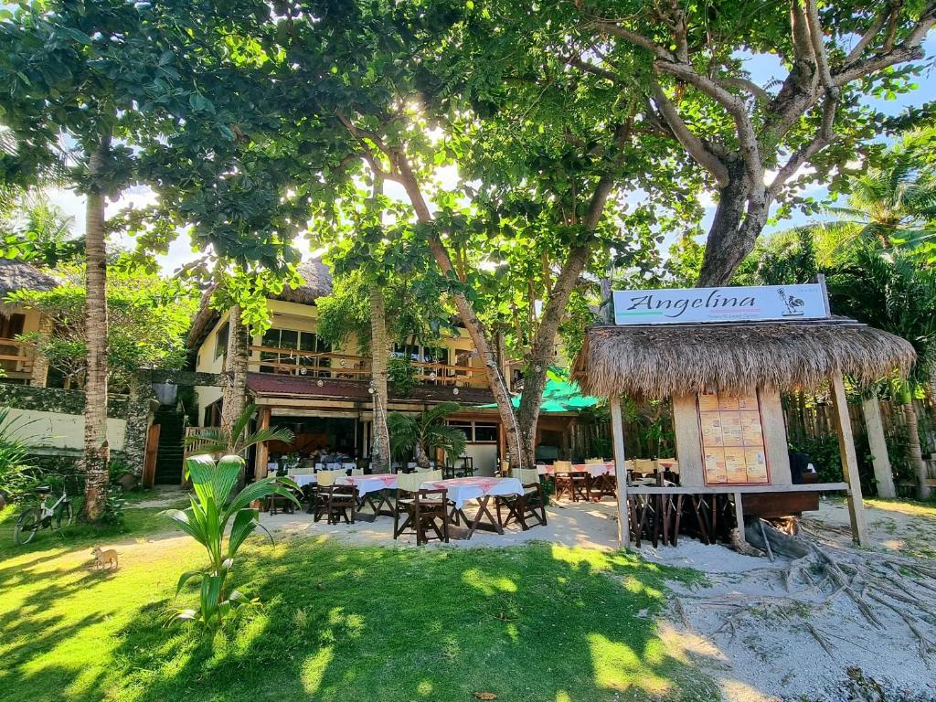 um restaurante com mesas e cadeiras num quintal em Angelina Beach Resort & Italian Restaurant Malapascua em Malapascua Island