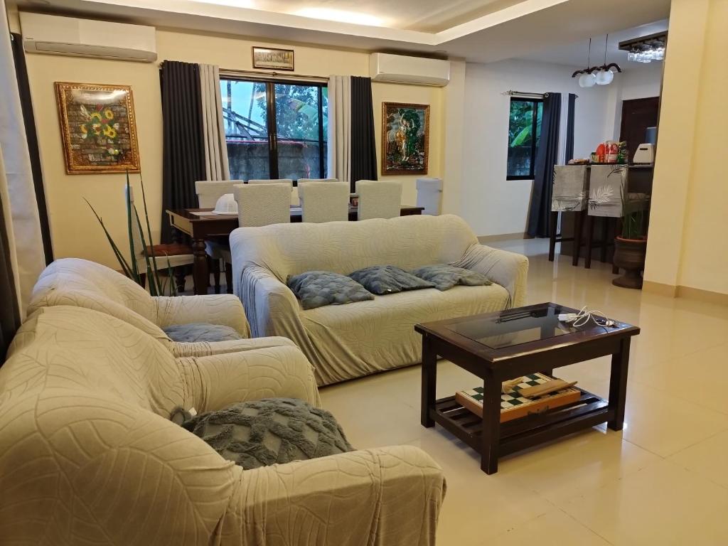 uma sala de estar com dois sofás e uma mesa de centro em Bohol Sweet Home em Guindulman