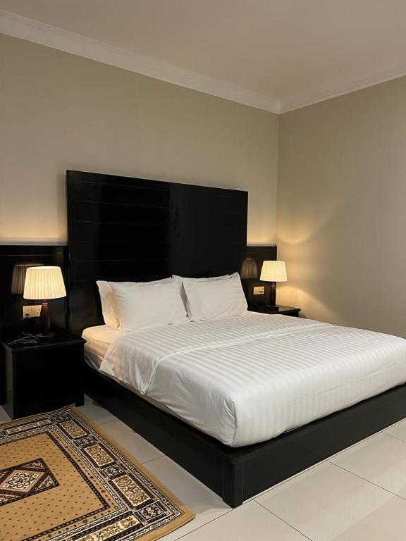 a bedroom with a large bed with a black headboard at Aneeda Inn in Pantai Cenang