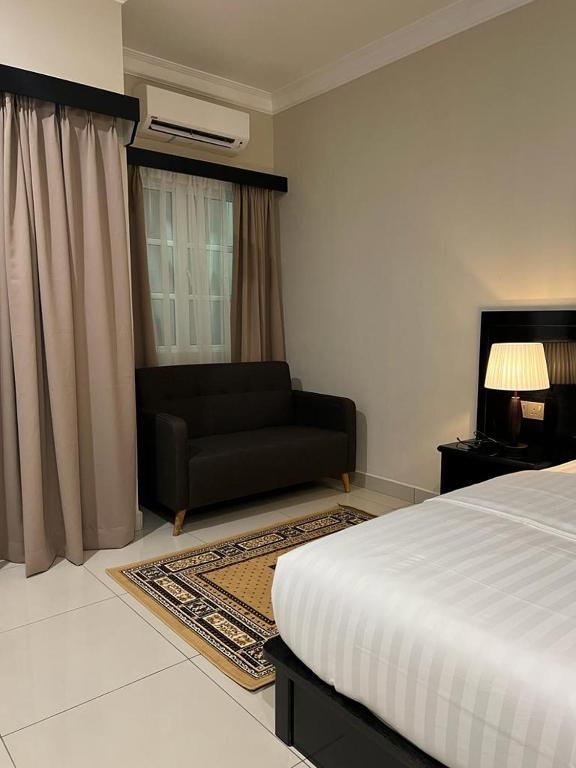 a bedroom with a bed and a couch in it at Aneeda Inn in Pantai Cenang
