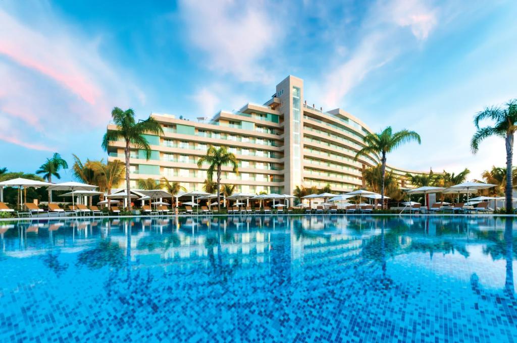 a beach scene with a large swimming pool at Palacio Mundo Imperial Riviera Diamante Acapulco in Acapulco