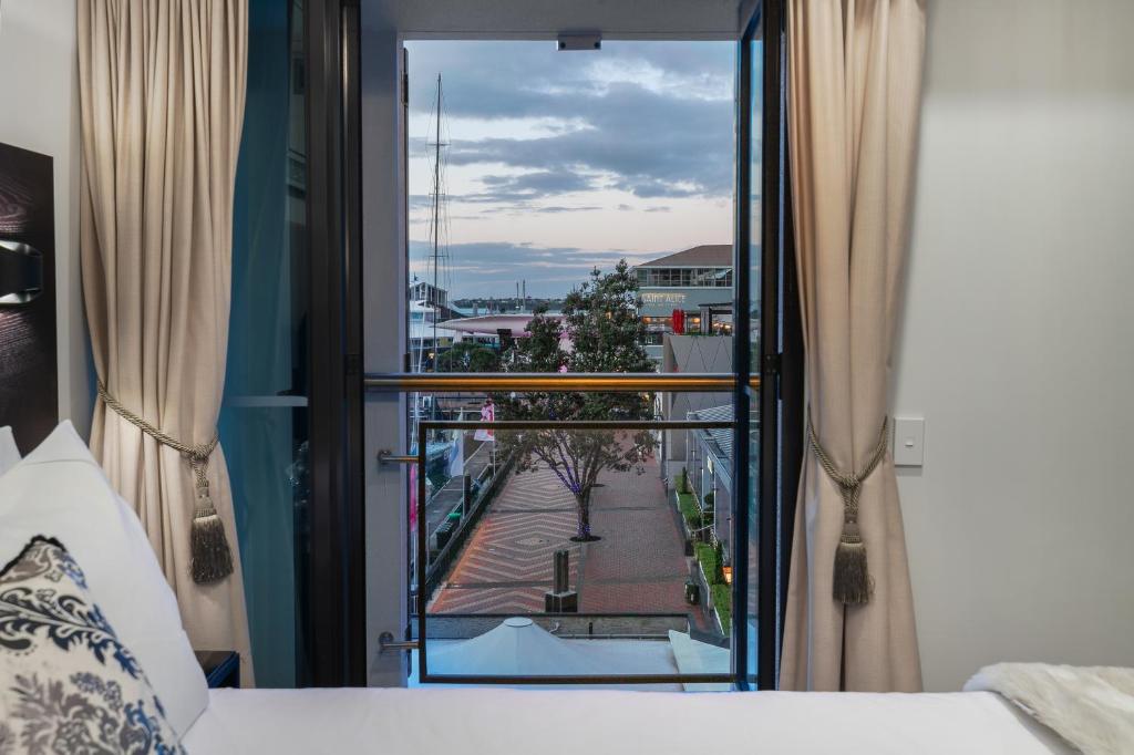 a bedroom with a bed and a view of a courtyard at Extravagant Escape in Auckland