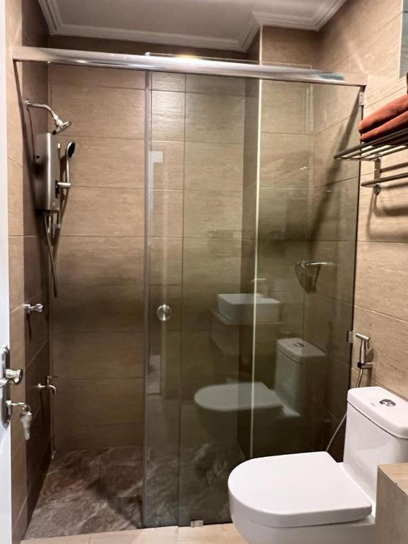 a bathroom with a glass shower with a toilet at Aneeda Inn in Pantai Cenang