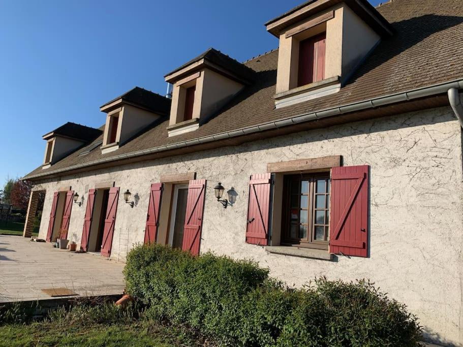 un edificio con persiane rosse di Belle maison spacieuse avec grand jardin 