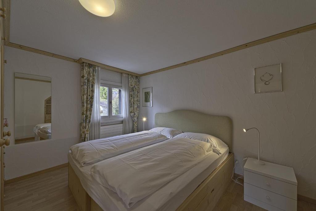 una camera con un letto e un grande specchio di Chesa da la Posta - Silvaplana a Silvaplana