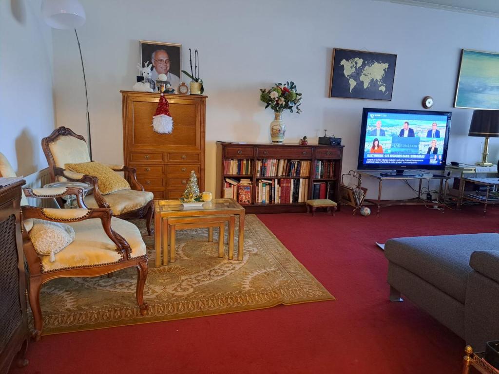 a living room with a couch and a tv at Chambre chez Habitant près Aéroport - Palexpo - ONU de Genève in Geneva