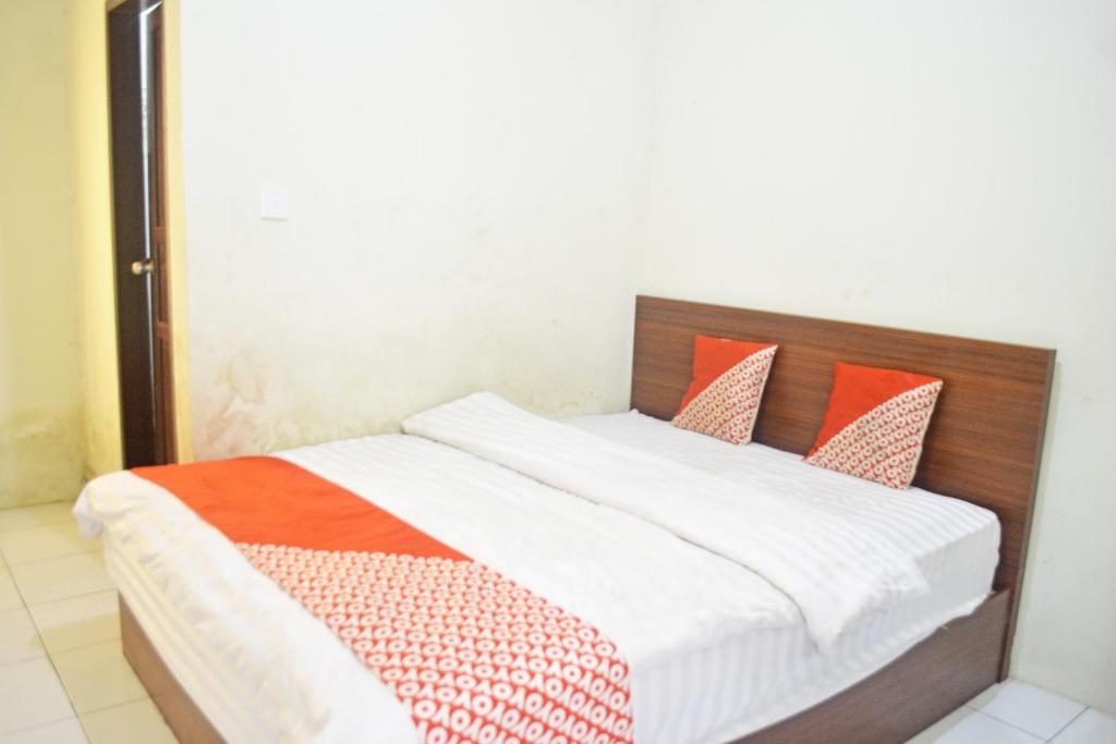 سرير أو أسرّة في غرفة في OYO 2731 MIM Guest House Syariah