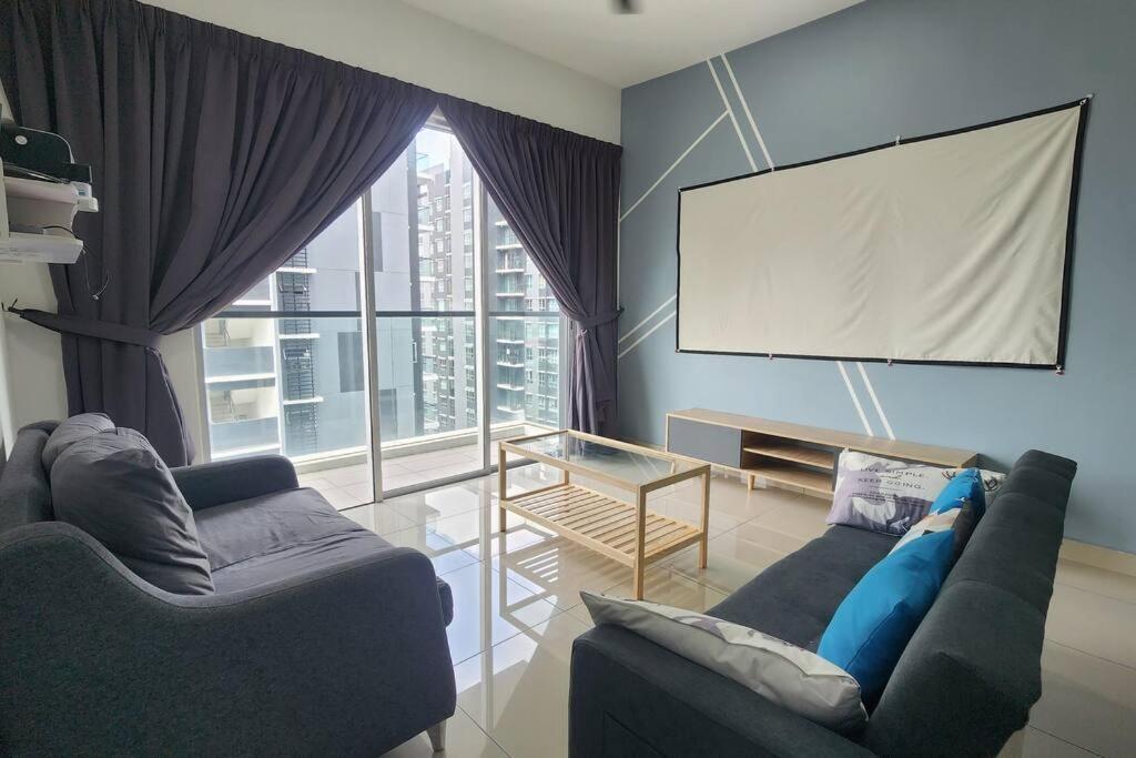 a living room with two couches and a large window at Cinema Blue Ocean 3 bedroom house kids water park in Shah Alam
