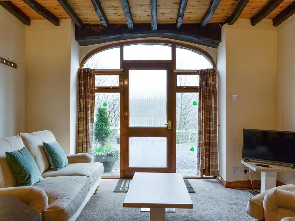 a living room with a couch and a large window at Doddick Chase Cottage - Uk1363 in Threlkeld