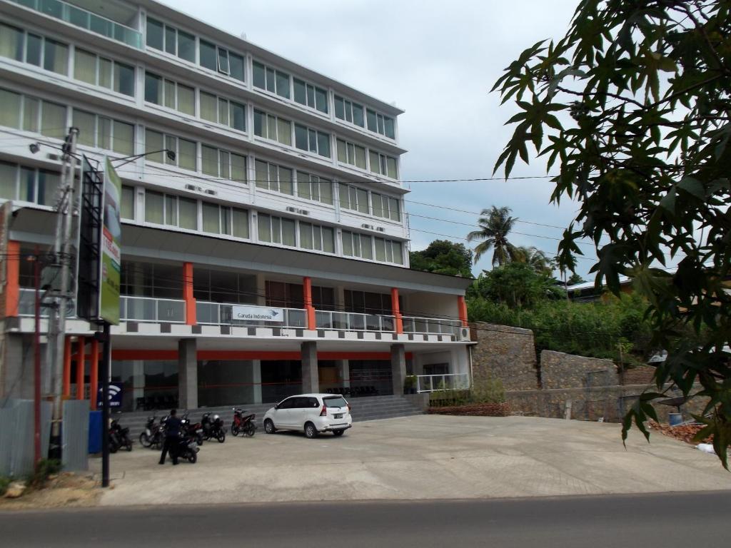 un coche blanco estacionado frente a un edificio en L Bajo Hotel, en Labuan Bajo