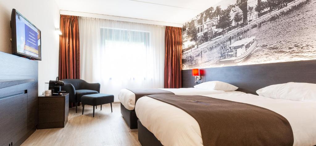 a hotel room with two beds and a television at Bastion Hotel Breda in Breda