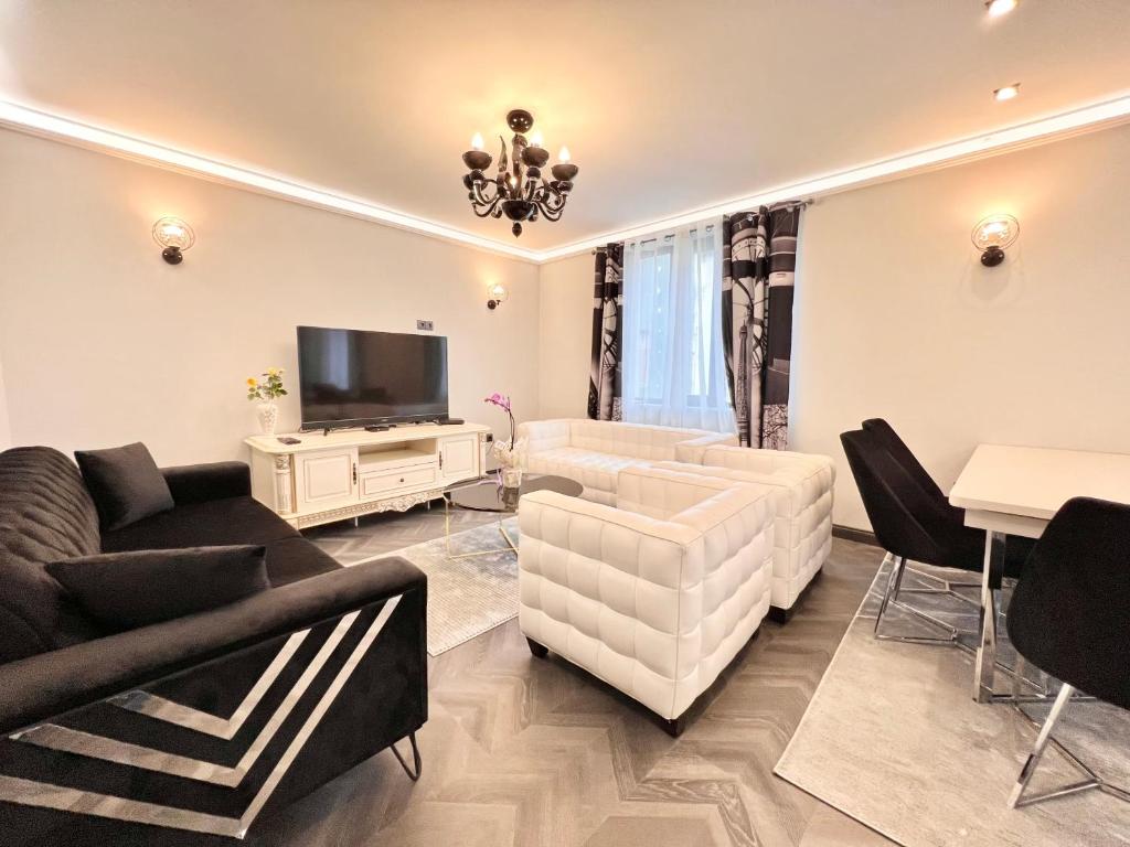 sala de estar con muebles blancos y TV de pantalla plana en Апартаменти Стефани en Plovdiv