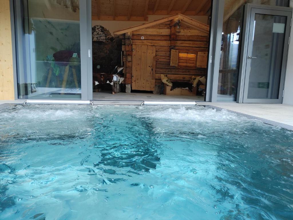 ein großer Pool mit Wasser vor einem Haus in der Unterkunft Crusch Alba Studio Sta Maria in Sta Maria Val Müstair
