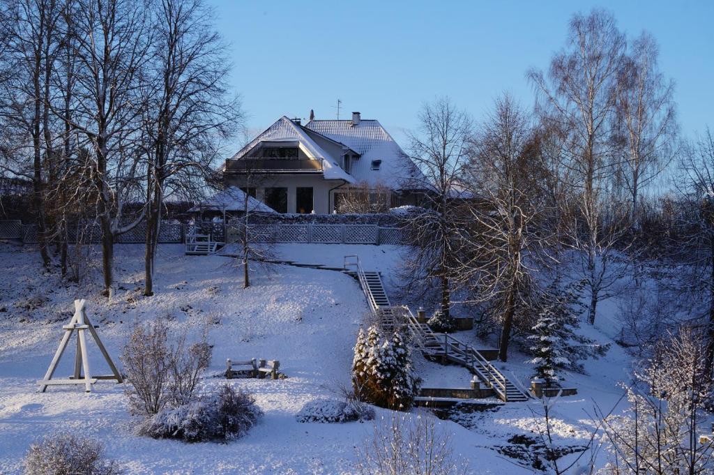 een huis in de sneeuw met een trap voor de deur bij Jaunkrastmaļi in Kandava