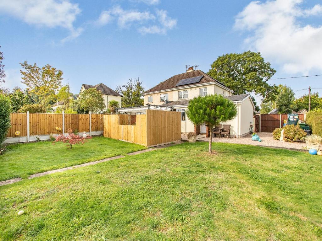 a backyard with a wooden fence and a house at Flyby Cottage in Symonds Yat