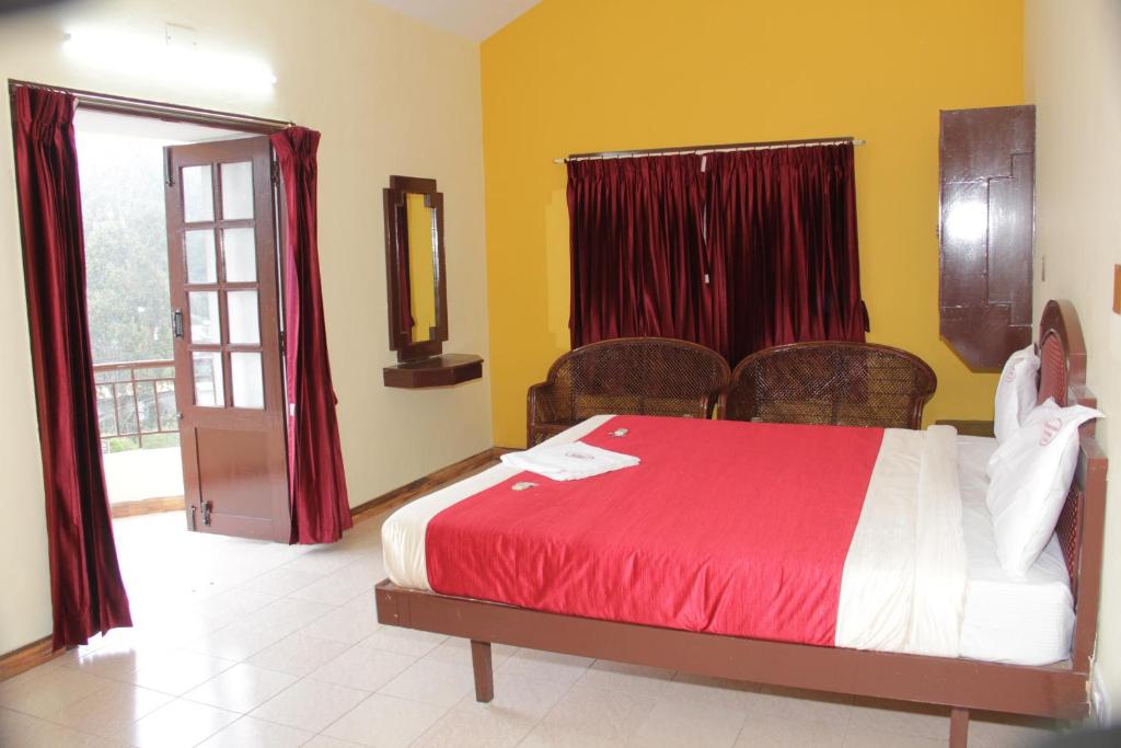 科代卡那的住宿－RPM Residency，一间卧室配有一张带红色床单的床和一扇窗户。