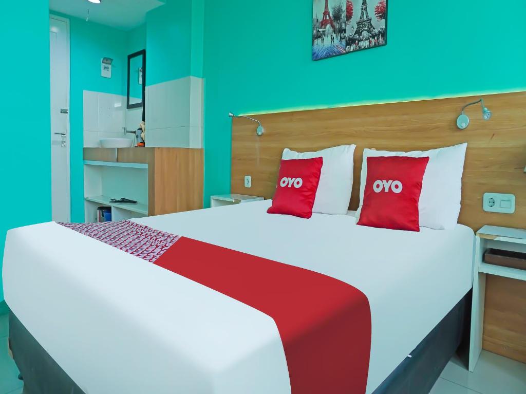 una camera da letto con un grande letto con cuscini rossi di OYO 90391 Gkitroom a Karawang