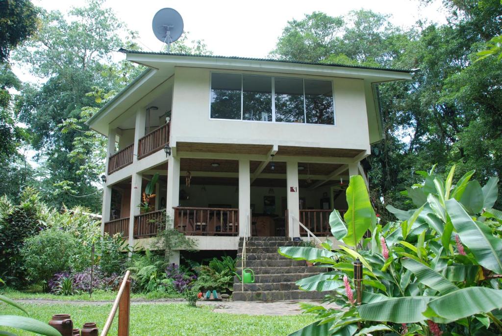 uma casa com grandes janelas e um alpendre em Heliconia Island em Sarapiquí