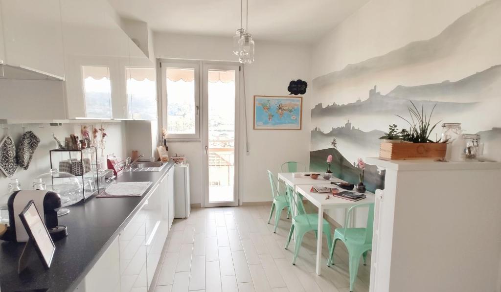 a kitchen with a table and green chairs at B&B Le Albarelle in Alba