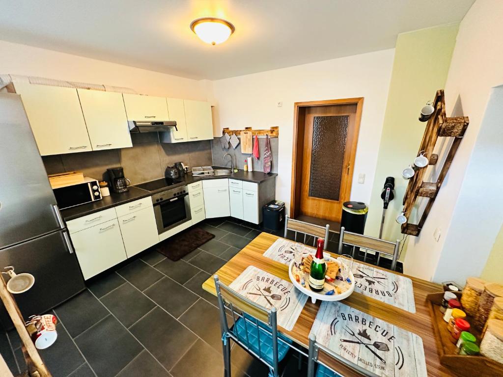 a kitchen with white cabinets and a table and chairs at Gemütliche Wohnung in Grünhainichen Erzgebirge in Grünhainichen