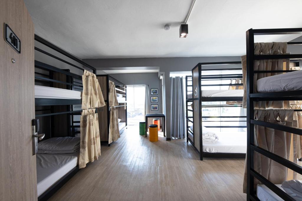 a dorm room with bunk beds and a room with a fireplace at SLEEP TO FLY HOTEL & HOSTEL suvarnabhumi airport in Bangkok