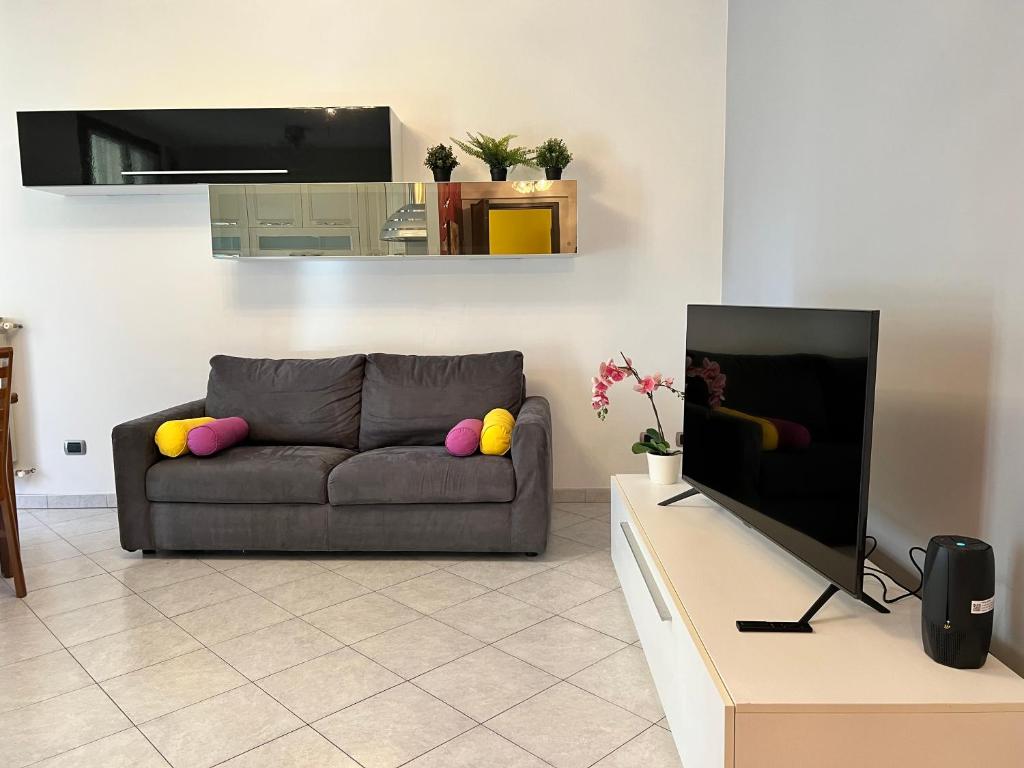uma sala de estar com um sofá e uma televisão de ecrã plano em Bnbook-Casa Andrea em Cardano al Campo