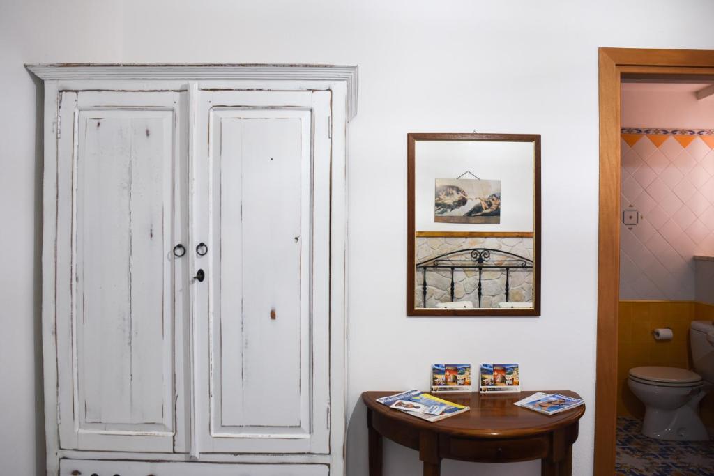 a bathroom with a white door and a table at B&B Antico Palmento in Lipari